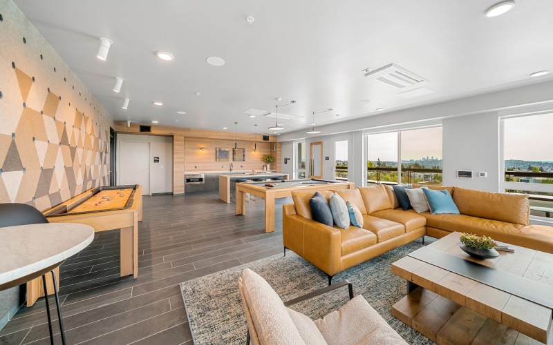 a clubroom with a couch, tables and chairs