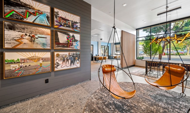 a clubroom with hanging chairs and wall art